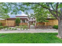 Inviting home exterior with landscaped front yard, mature trees, and charming architectural details at 980 S Locust St # D, Denver, CO 80224