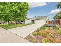 Charming one-story home with a well-maintained lawn, mature tree, and a large driveway at 9431 W Jewell Pl, Lakewood, CO 80227