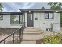 Updated ranch home exterior featuring a modern gray brick facade and landscaping at 4735 W Bayaud Ave, Denver, CO 80219