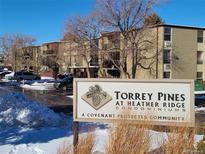 Torrey Pines Condominium at Heather Ridge, a covenant-protected community in a complex surrounded by trees and partial snow at 2281 S Vaughn Way # 214A, Aurora, CO 80014