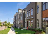 A row of modern townhomes showcases stylish brickwork and a landscaped lawn against a clear blue sky at 22 Oneida Ct, Denver, CO 80230