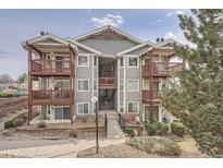 Condo building with balconies, green landscaping, and neutral gray siding, exuding charm and comfort at 17652 E Loyola Dr # 2032R, Aurora, CO 80013
