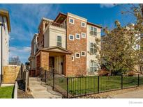 Beautiful three story townhouse with a blend of traditional brick and stucco, and a charming small front yard at 2050 N High St, Denver, CO 80205