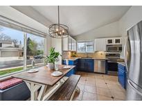 Bright eat-in kitchen with blue and white cabinets and stainless appliances at 646 S Joplin St, Aurora, CO 80017