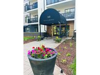 Inviting entrance to 345 Fillmore with black awning, landscaping, and benches for residents and visitors at 345 Fillmore St # 203, Denver, CO 80206