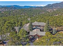 Stunning home exterior with mountain views surrounded by lush trees for a private feel at 2817 Keystone Dr, Evergreen, CO 80439