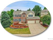 Charming two-story brick home with a three-car garage and beautifully landscaped front yard at 8646 Fawnwood Dr, Castle Pines, CO 80108