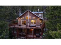 Charming cabin-style home with a large deck nestled in a lush, wooded setting at 302 Texas Dr, Idaho Springs, CO 80452