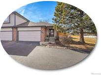 Charming townhome featuring a two-car garage, landscaped front yard, and inviting entryway at 6321 S Harrison Ct, Centennial, CO 80121