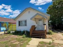 Charming single-story home with white siding, blue trim, covered entrance, and well-manicured yard at 240 N 4Th Ave, Brighton, CO 80601