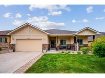 Beautiful tan single-story home featuring a well-manicured front yard and an attached two-car garage at 9744 W Ontario Pl, Littleton, CO 80128