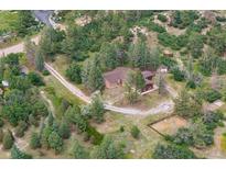 Idyllic aerial view of a home nestled amongst a lush green forest on a sunny day at 7390 Rafter Rd, Franktown, CO 80116