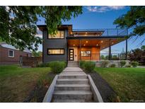 Modern two-story home with sleek gray siding, wood accents, and a second-story balcony at 1490 S Vine St, Denver, CO 80210