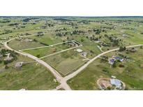 Expansive aerial view of a property surrounded by green fields and scattered houses in a rural community at 34586 Morgan Trl, Elizabeth, CO 80107