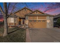 Charming home with a two-car garage, brick accents, and well-maintained lawn at 1479 Short Grass Ct, Castle Rock, CO 80109