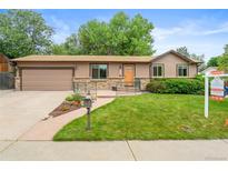 Charming single-Gathering home featuring well-manicured front yard and an attached two-car garage at 10563 Pierson Cir, Broomfield, CO 80021