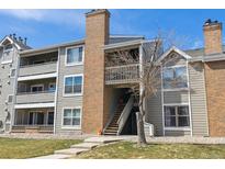 Multi-level condo building with brick chimney, wood siding, and stairs leading to the upper units at 12093 W Cross Dr # 304, Littleton, CO 80127