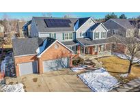 Two-story home with brick and siding, solar panels, and attached garage at 6610 S Waco Way, Aurora, CO 80016