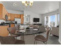 Bright, open-concept living space with modern finishes and a dining area connected to the kitchen at 14321 E Tennessee Ave # 1-301, Aurora, CO 80012