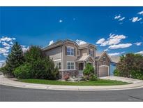 Inviting home with landscaped front yard, two-car garage, and charming stone accents at 10761 Hillsboro Cir, Parker, CO 80134