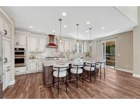 Bright kitchen features an island with seating, pendant lights, and stainless steel appliances at 10761 Hillsboro Cir, Parker, CO 80134