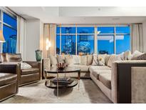 Modern living room featuring a comfortable sectional sofa and expansive windows showcasing a vibrant city view at 1411 Wynkoop St # 806, Denver, CO 80202