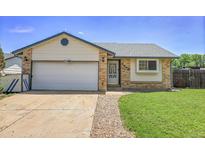 Charming single-story home featuring a well-maintained front yard, attached garage and inviting entrance at 7610 S Garland St, Littleton, CO 80128