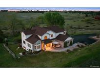 Stunning two-story home featuring a large front yard and an inviting outdoor seating area at 7289 Stroh Rd, Parker, CO 80134