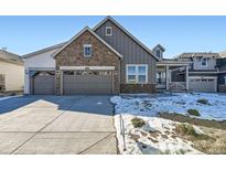 Charming two-story home with a stone facade and three-car garage, complemented by a well-maintained front yard at 3856 Treadway Pt, Castle Rock, CO 80108