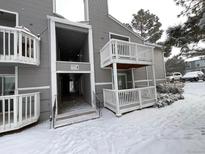 Exterior view of condo building with snow on the ground at 4450 S Pitkin St # 128, Aurora, CO 80015