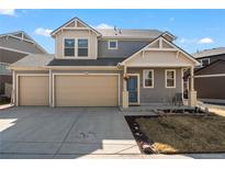 Charming two-story home featuring a two-car garage, gray siding, and a welcoming blue front door at 18284 E 52Nd Pl, Denver, CO 80249