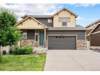 Beautiful two-story home with a teal front door and well-maintained landscaping at 1027 Auburn Dr, Erie, CO 80516