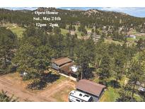 Beautiful home nestled amongst mature trees with mountain views and a large RV or boat parking area at 29827 Gigi Rd, Evergreen, CO 80439