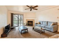 Comfortable living room featuring a fireplace, ceiling fan, and sliding glass door to the exterior at 10293 E Peakview Ave # F104, Englewood, CO 80111