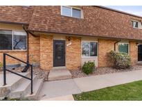 Charming brick townhome featuring a well-maintained walkway and front yard landscaping at 63 S Holman Way, Golden, CO 80401