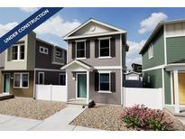 Two-story craftsman style home with gray siding, white trim, and landscaping at 10306 Uvalda Ct, Commerce City, CO 80022
