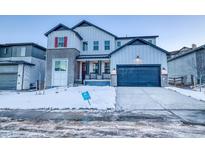 Two-story home with gray siding, a blue garage door, and a snowy front yard at 8512 Orchard City Dr, Littleton, CO 80125