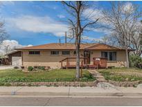 Charming brick home featuring a well-kept lawn, a wooden porch, and a welcoming entrance at 4395 E Arapahoe Pl, Centennial, CO 80122