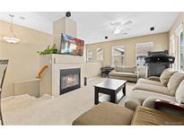 Comfortable living room featuring a cozy fireplace, entertainment center, and ample seating at 32 Whitehaven Cir, Highlands Ranch, CO 80129