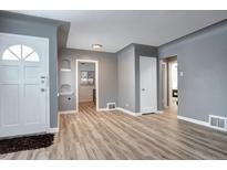 Inviting living room featuring sleek floors and white trim doors, offering a bright and modern aesthetic at 361 N Raleigh St, Denver, CO 80219