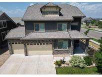 Beautiful two-story home featuring a three-car garage and a charming covered porch at 90 Pipit Lake Way, Erie, CO 80516