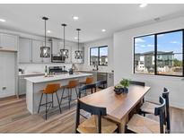 Bright, open kitchen featuring an island with seating, pendant lighting and stainless steel appliances at 2078 S Holly St # 3, Denver, CO 80222