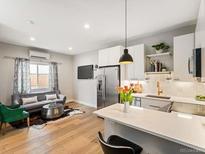 Open-concept living room flows to a modern kitchen, creating an inviting and stylish space at 4232 Jason St # 7, Denver, CO 80211