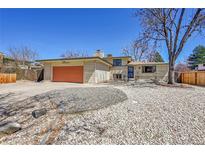 Charming ranch-style home with an orange garage door and landscaped front yard at 2826 S Lamar St, Denver, CO 80227