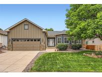 Charming home features a well-manicured lawn, mature tree and a two-car garage at 21107 Hawthorne Ln, Parker, CO 80138