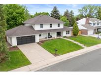 Charming two-story home featuring a well-manicured lawn and a spacious driveway with a modern-looking garage door at 5853 S Havana Ct, Englewood, CO 80111