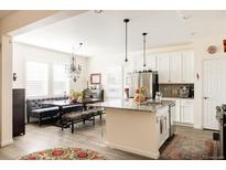 Bright kitchen features granite counters, an island with pendant lighting, stainless appliances, and an adjacent dining nook at 10845 Bear Cub Dr, Broomfield, CO 80021