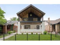 Stunning two-story home with modern design elements, including a balcony and manicured front lawn at 863 S Race St, Denver, CO 80209