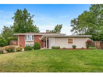 Charming single-story home featuring a well-maintained lawn, mature trees, and a cozy front porch at 8051 S Kendall Blvd, Littleton, CO 80128