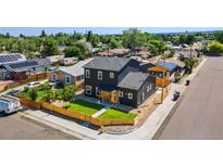 Modern two-story home features black siding, a well-kept lawn, and a charming wood fence at 550 S Raleigh St, Denver, CO 80219